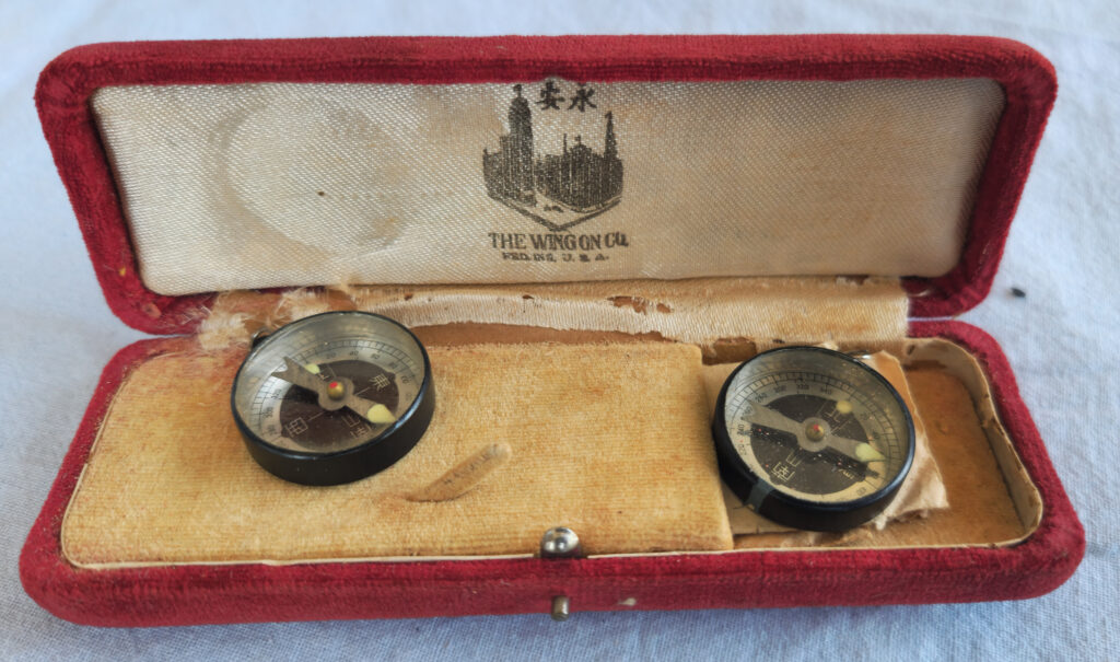 Two small compasses in a Wing On box